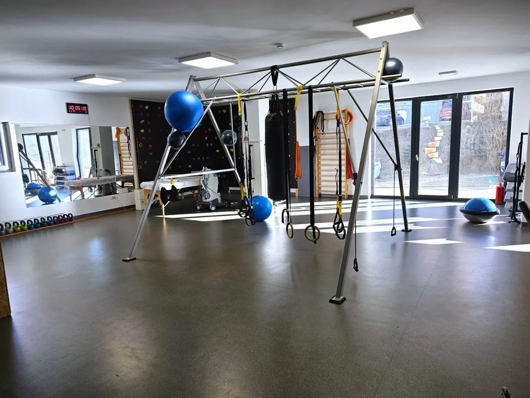 Sala RESET cu cadrul TRX, inele și mingi, luminată de geamurile mari